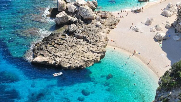 A coastal area with clear blue waters, rocky formations, and a sandy beach. - Vacation home "The White Myrtle" (Arbatax)