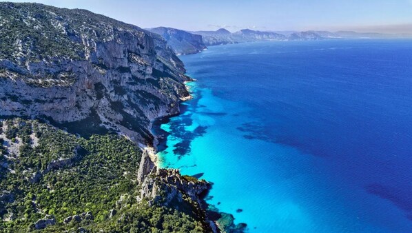 Paisaje costero con acantilados y un mar azul cristalino.