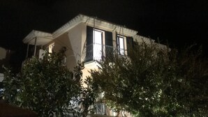 A house with a balcony and a lit window at night. - Vacation home "The White Myrtle" (Arbatax)