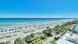 A beach resort with tents, sun loungers, and a pool area.