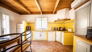 A kitchen with yellow walls, white cabinets, and a wooden ceiling. - Welcome to Filippi Furnished Bungalows! (PORTO-VECCHIO)