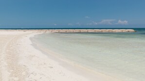 Ein Strand mit klarem Wasser und einem sandigen Ufer.