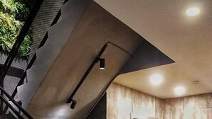 A staircase with a metal railing leading to a landing. - Nine Hotel Palembang (Palembang)