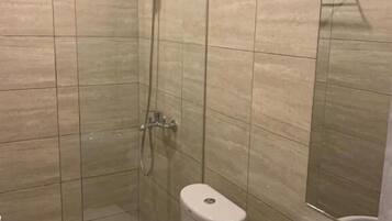 Un baño con ducha, inodoro y lavamanos.
