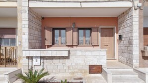 Un edificio con facciata in pietra, un balcone con ringhiera e una porta.