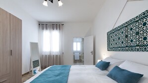 Una camera da letto moderna con un letto grande, un armadio, uno specchio e un decoro murale a motivi.