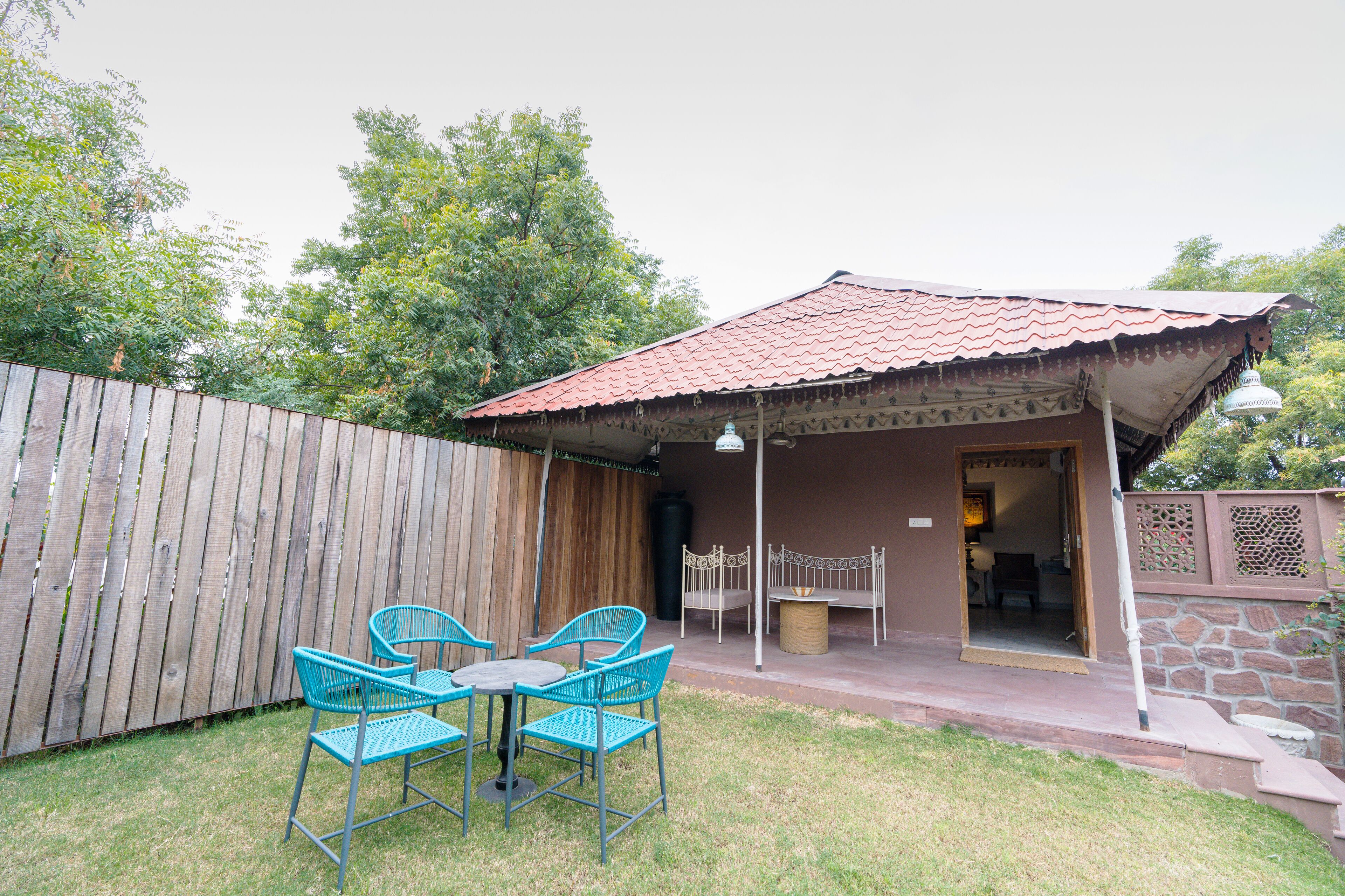 A patio with a table and chairs, a covered seating area, and a wooden fence.
