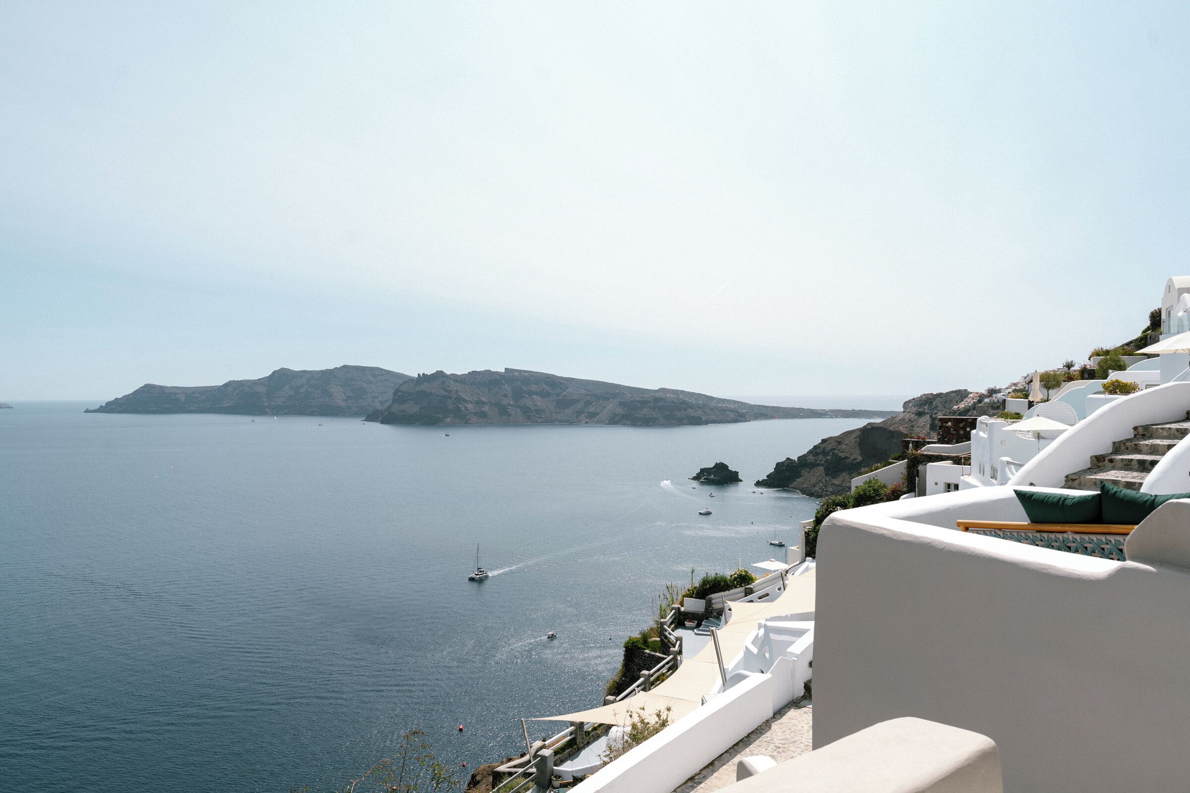 A coastal view with a white building, a clear sky, and calm sea.