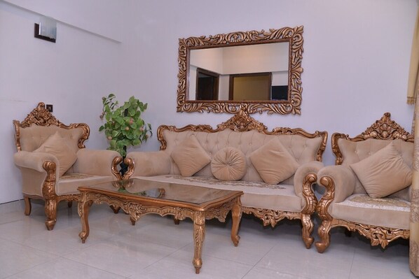 A room with a sofa set, a coffee table, and a mirror on the wall.
