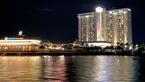 A high-rise hotel with a prominent sign, a waterfront view, and a well-lit beachfront area. - Hidden Gem Waterfront home in gated Country Club community on Lake Conroe.   (Montgomery)