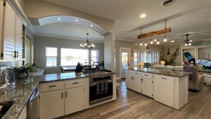 A spacious kitchen with a large island, built-in appliances, and ample natural light from large windows. - Hidden Gem Waterfront home in gated Country Club community on Lake Conroe.   (Montgomery)