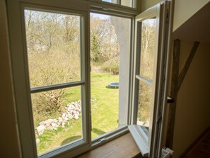 Ein Zimmer mit einem großen Fenster mit Blick auf einen Rasen und ein Trampolin.