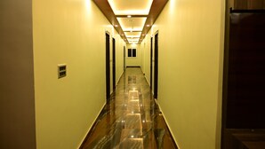 Un pasillo con piso brillante y reflectante, e iluminación empotrada.