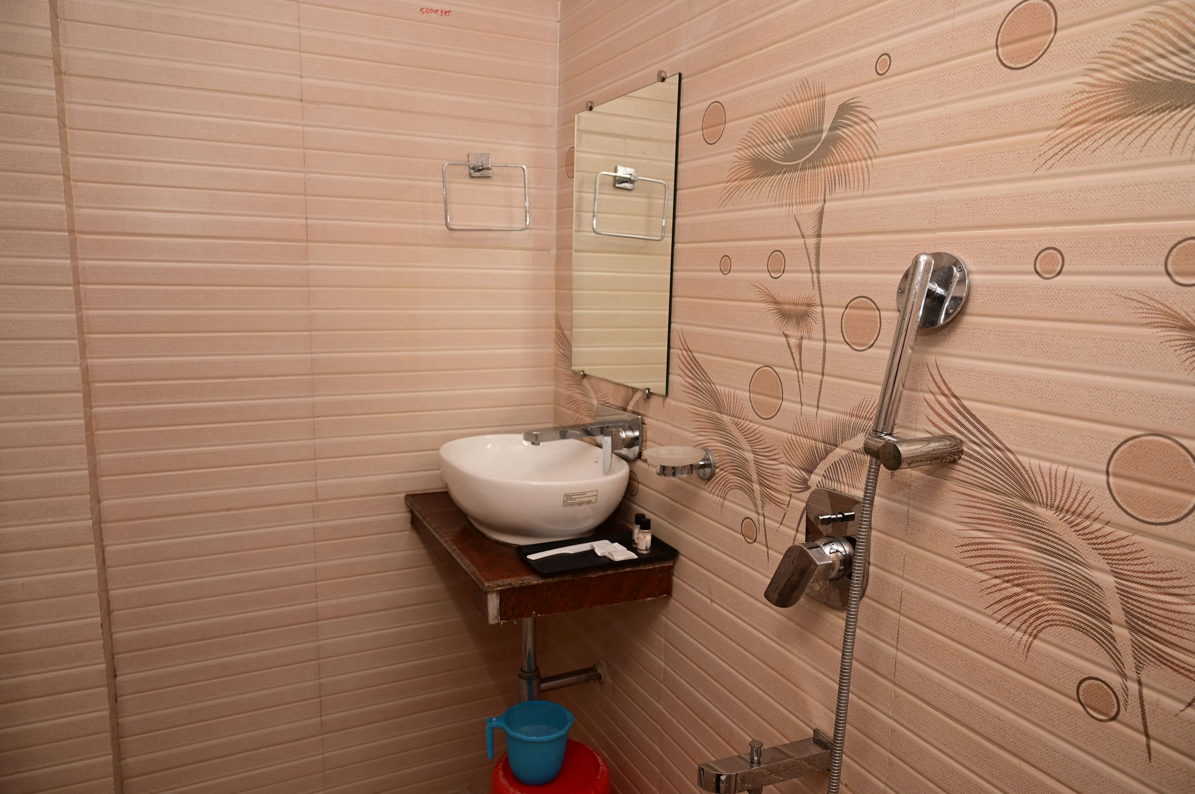 A bathroom with a sink, mirror, and shower.