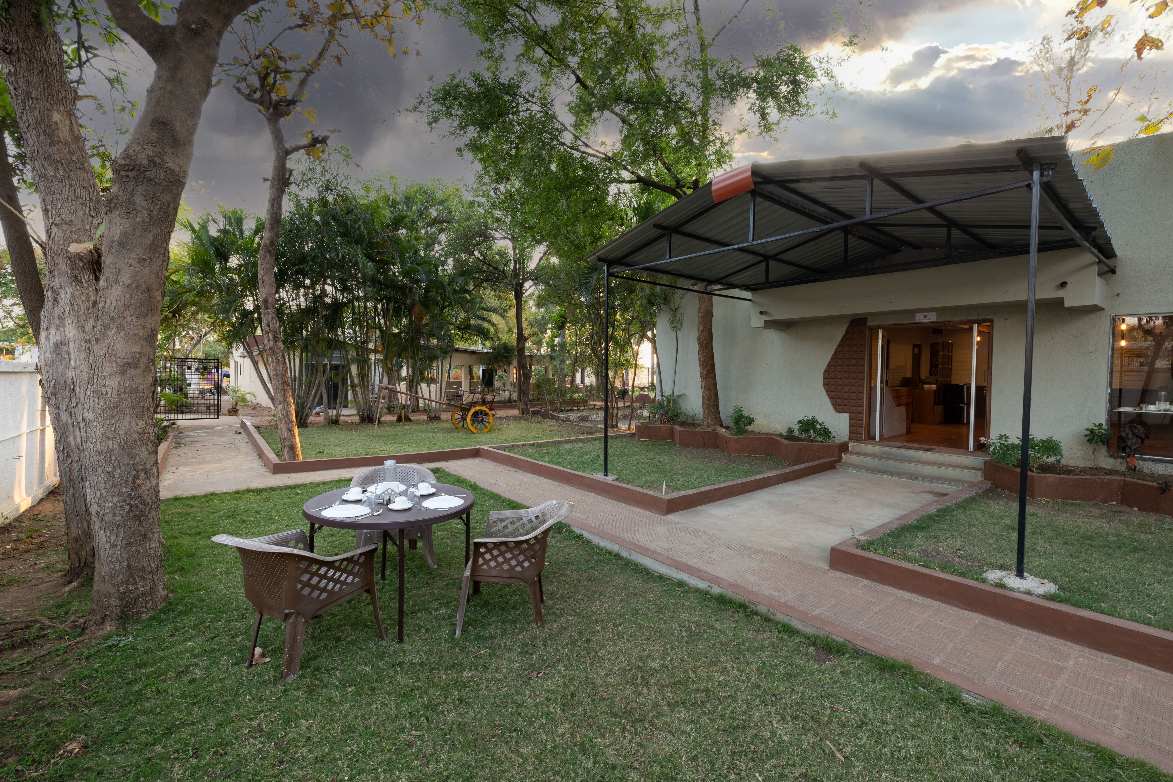 A patio area with a covered seating area, a pathway, and a building entrance.