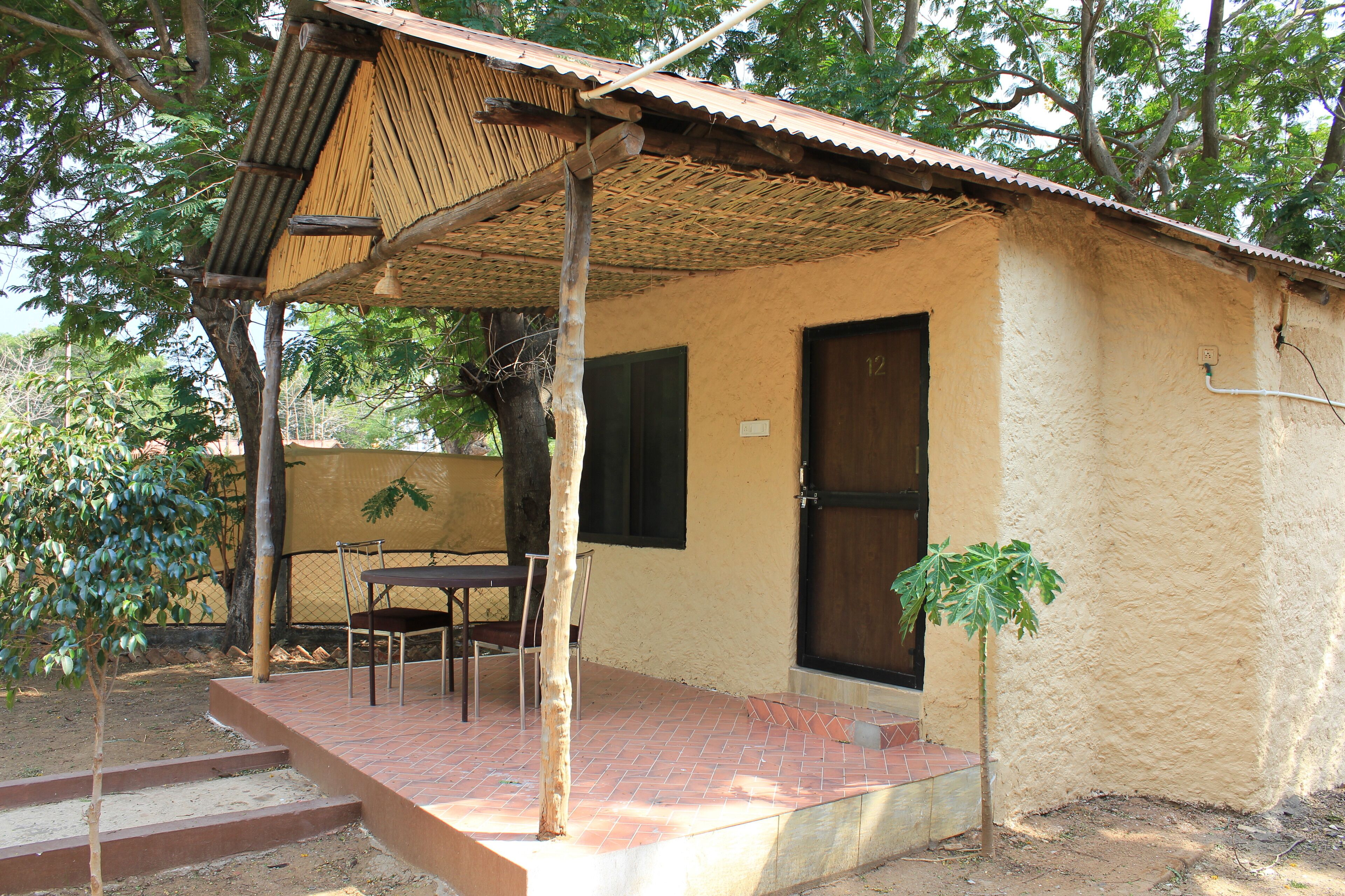 A small building with a tiled patio, a door, and a window.