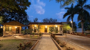 A building with a central entrance, a covered patio area, and a parking lot. - Avadale Tadoba - Stag Groups Not Allowed (Bhadravathi)