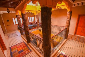 Una escalera con barandillas ornamentadas y un tapete estampado.