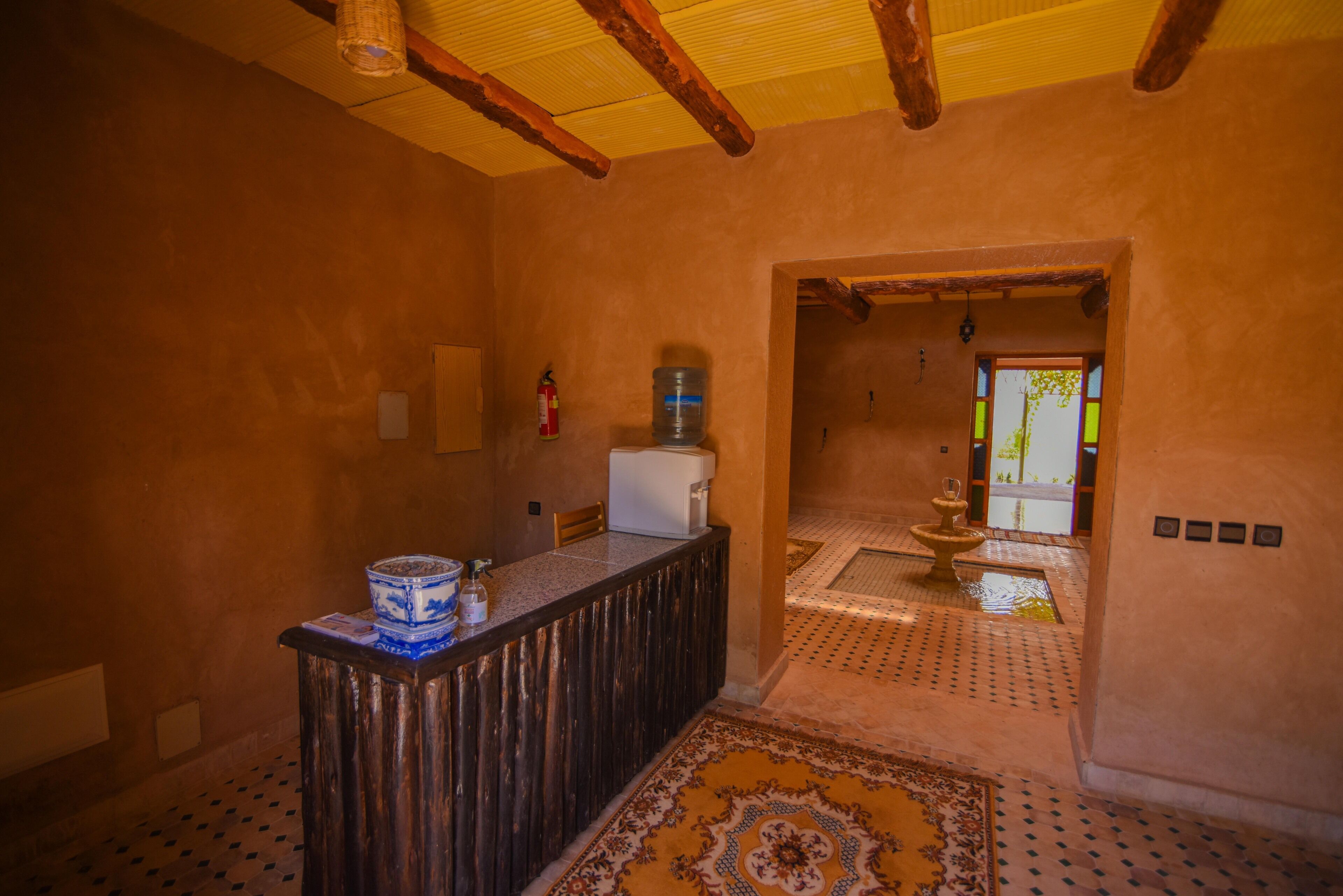 Una cocina con encimera de madera, dispensador de agua y refrigerador.
