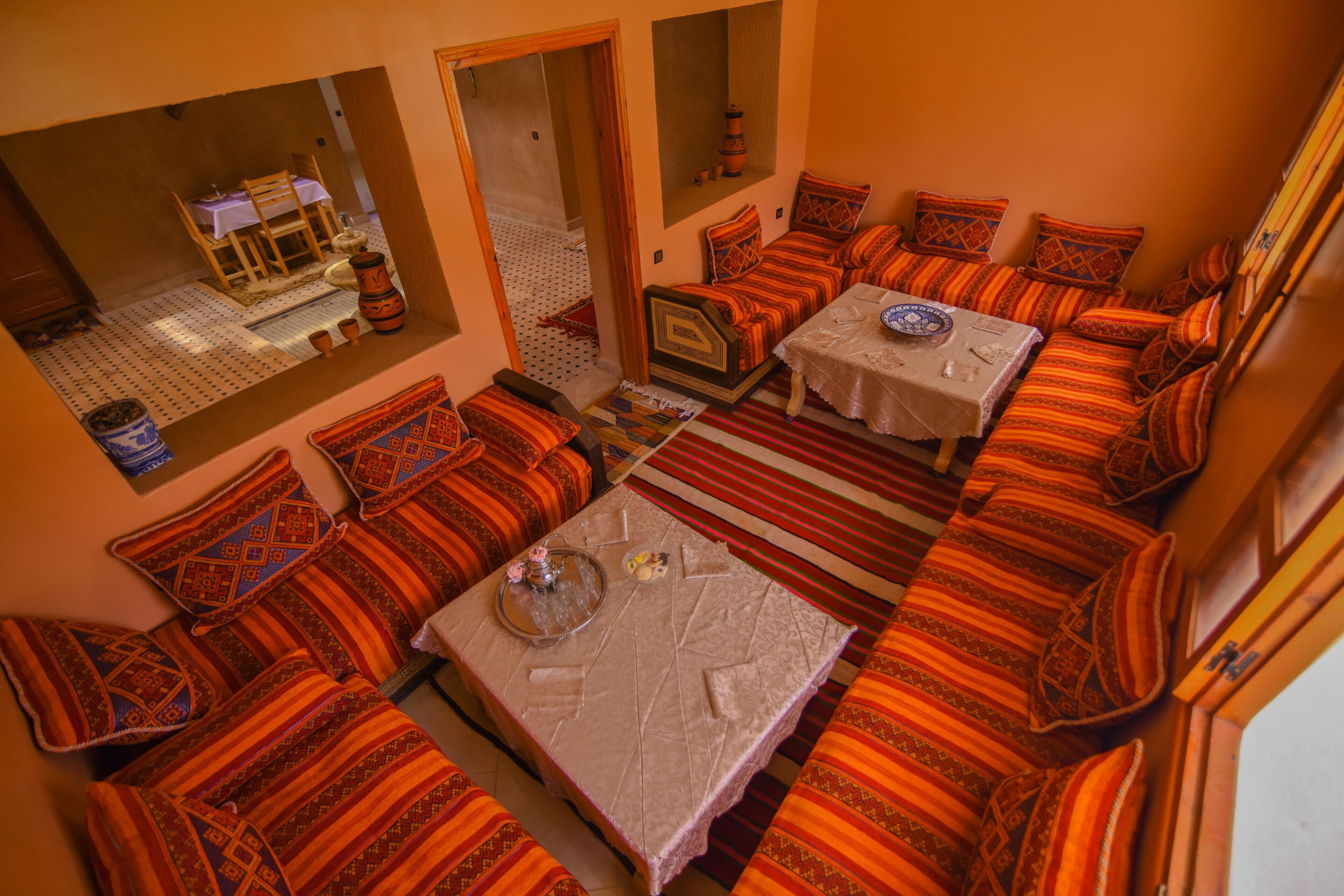 A cozy room with a sofa set, a dining table, and a small kitchen area.