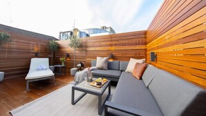 An outdoor patio with a grey sofa, a lounge chair, and a coffee table. - Hidden Gem in Covent Garden, contemporary design with private terrace (London)