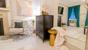 A spacious room with a bed, a chair, a dresser, and a small table with a vase of flowers. - Hidden Gem in Covent Garden, contemporary design with private terrace (London)