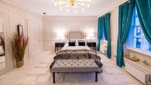 A bedroom with a large bed, bedside tables, a chandelier, and teal curtains. - Hidden Gem in Covent Garden, contemporary design with private terrace (London)