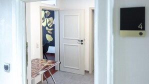 A hallway with a white door, a number 4 sign, and a table with a magazine. - ANA Suites Augsburg City Center (Augsburg)