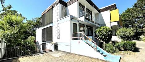 A modern two-story building with a staircase leading to a balcony.