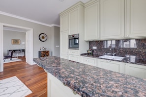 A kitchen with white cabinets, a granite countertop, and a built-in oven. - Pure Luxury Suite Friendly Calm Residence Prague (Hlavní město Praha)
