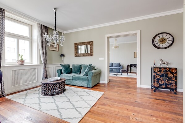 A living room with a sofa, a patterned rug, a round table, and a decorative cabinet. - Pure Luxury Suite Friendly Calm Residence Prague (Hlavní město Praha)