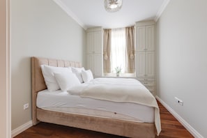 A bedroom with a bed, a wardrobe, and a window with curtains. - Pure Luxury Suite Friendly Calm Residence Prague (Hlavní město Praha)