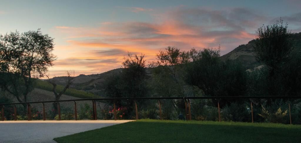 A fenced outdoor area with a grassy lawn and trees, likely part of a property or resort.