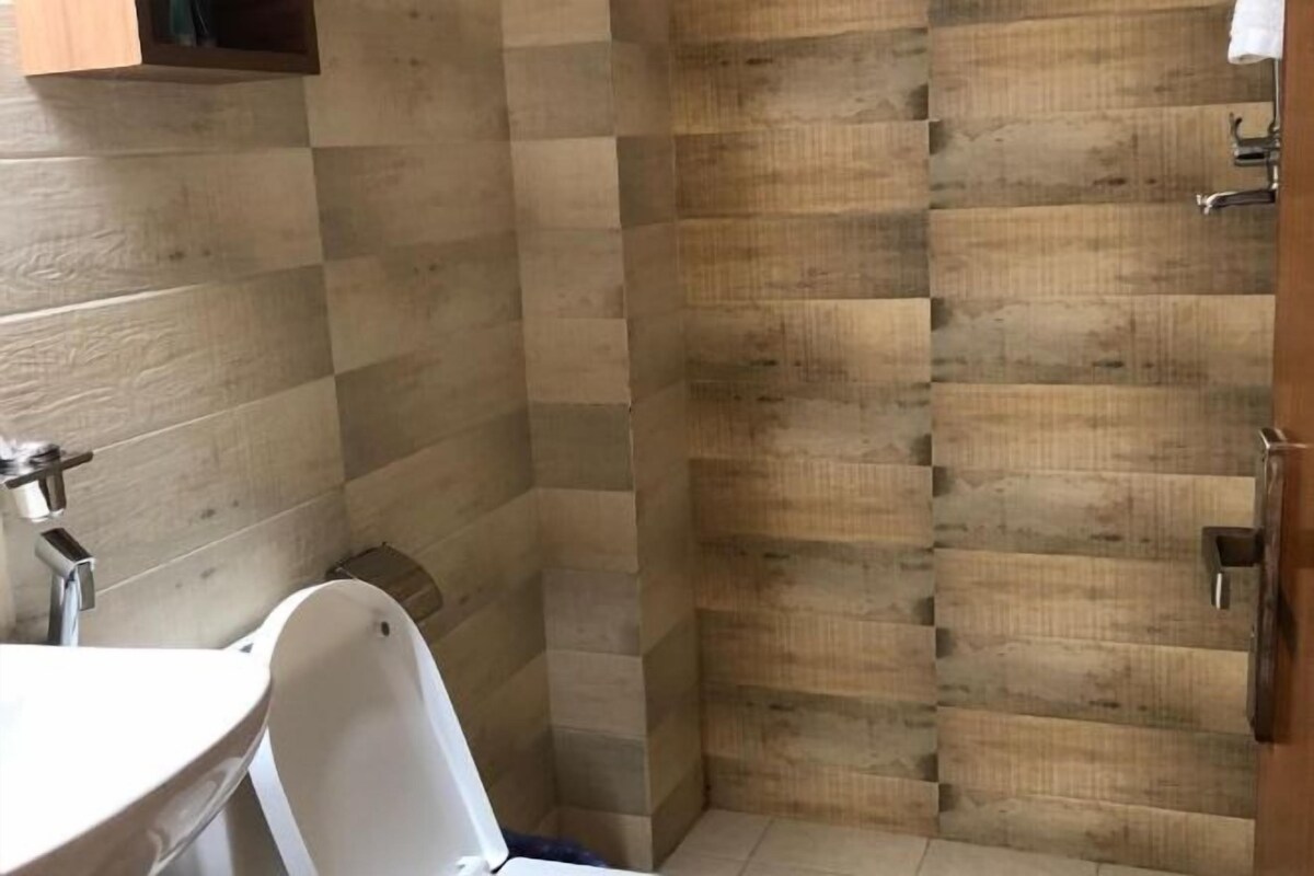 A bathroom with a wooden wall, a white bathtub, and a sink with a mirror.