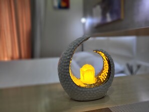 A decorative object with a crescent shape and a glowing element in the center, placed on a table in a room with a blurred background. - Black Sea Apartments Alliance Palace (Batumi)