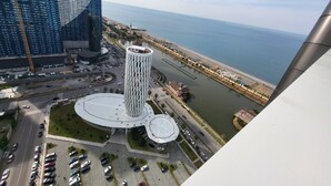 A high-rise building with a distinctive geometric design, a central circular plaza, and a waterfront view. - Black Sea Apartments Alliance Palace (Batumi)