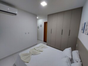 A hotel room with a bed, a wardrobe, and an air conditioning unit. - Mana Beach Experience- Porto de Galinhas (Ipojuca)
