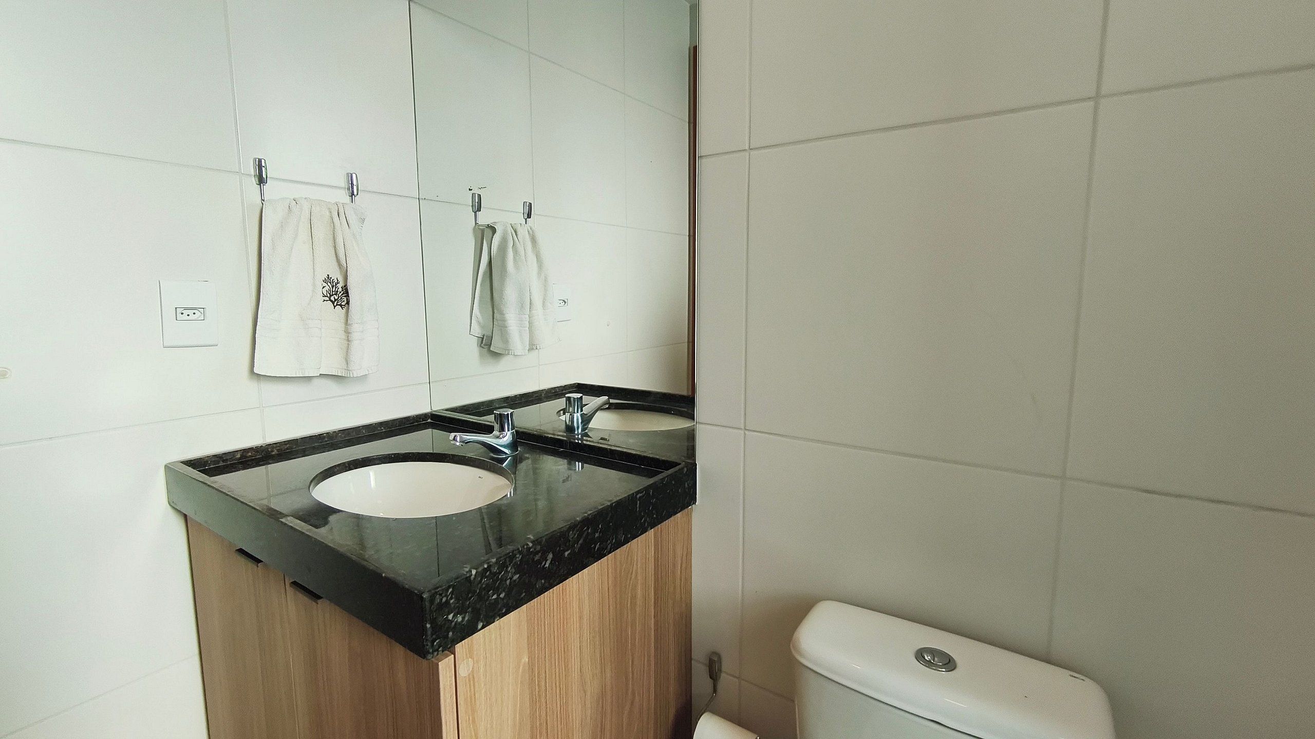 Une salle de bain avec un lavabo, un miroir et des toilettes.