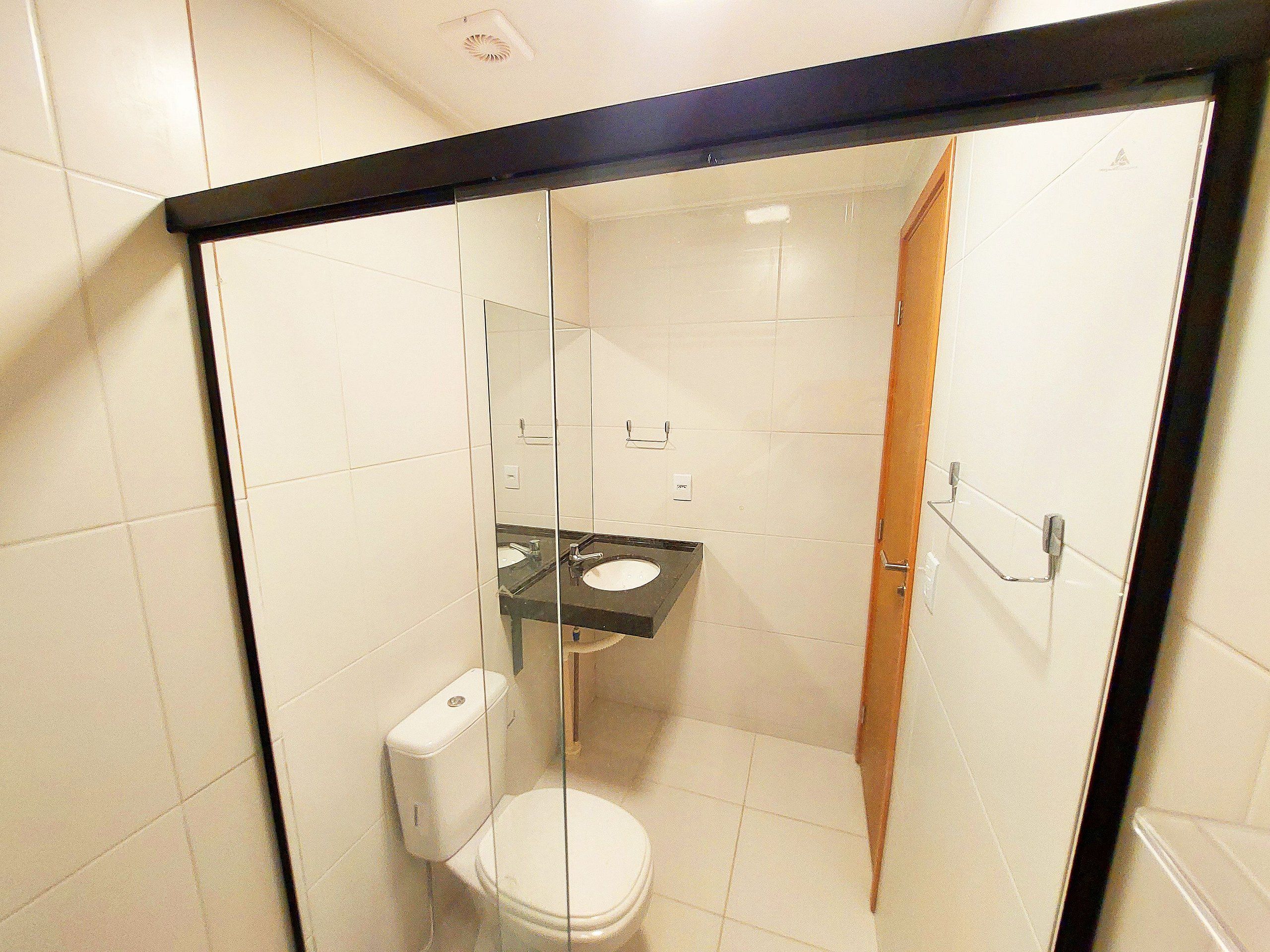 A glass-enclosed shower stall with a toilet and sink.