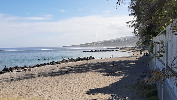 A beach with a rocky shoreline, clear blue water, and a few people in the distance. - Comfortable T3 with terrace 5 minutes walk from Saint-Leu beach (Saint-Leu)