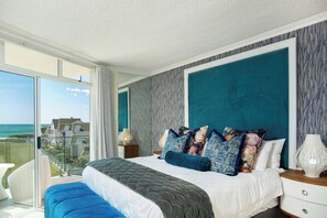 Ein Schlafzimmer mit einem großen Bett, Meerblick und einem Balkon.