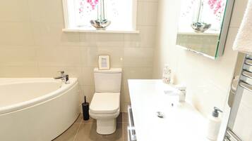 Un baño con bañera, inodoro y lavabo.