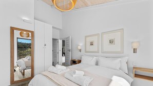 A modern hotel room with a large bed, a mirror, a wooden ceiling, and a view of the outdoors. - San Lameer Villa 2533 (Southbroom)