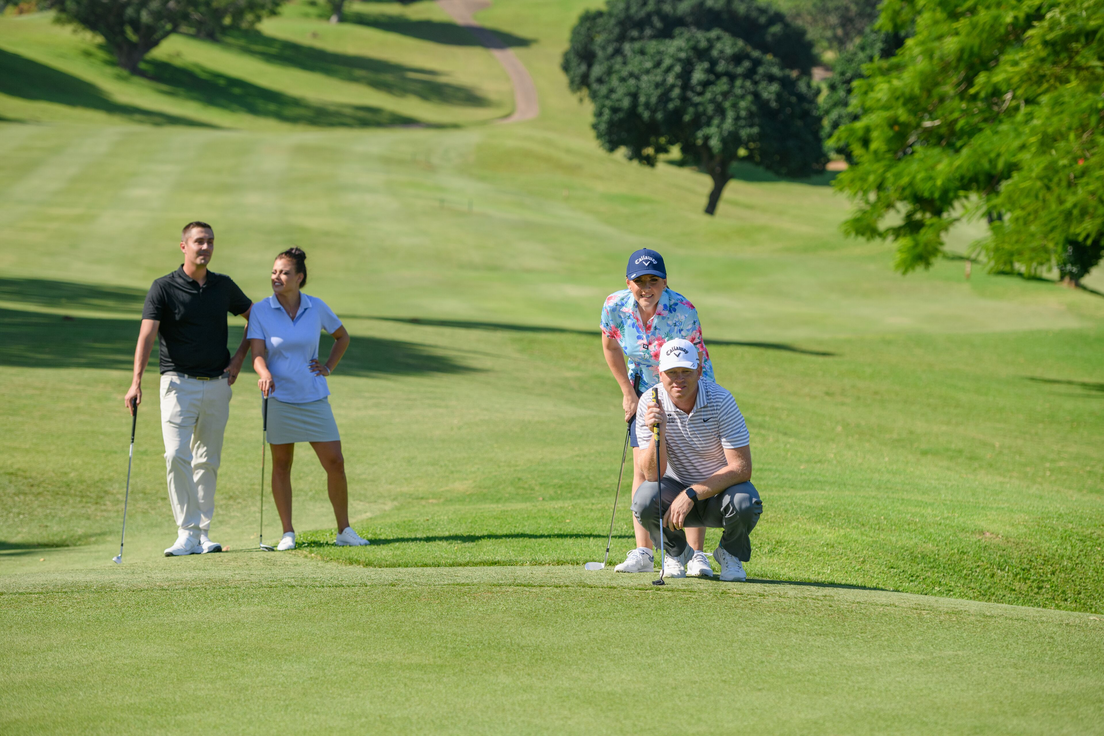 A golf course with players and caddies.