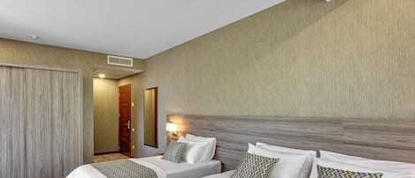 Une chambre d’hôtel avec deux lits, une tête de lit en bois et un sol recouvert de moquette.