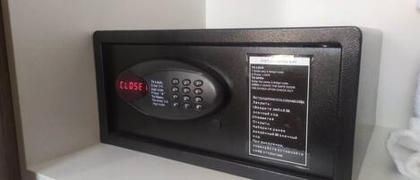 Una cassaforte digitale con tastierino e schermo che mostra la scritta “CLOSE”. Istruzioni per l'uso visibili su un'etichetta applicata alla cassaforte.