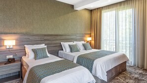 A hotel room with two beds, a wooden headboard, a telephone on the nightstand, and a window with curtains. - Vinum Hotel (Tbilisi)