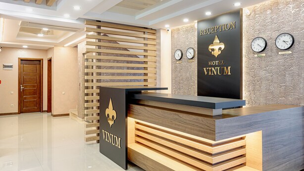 A hotel reception desk with a modern design, featuring a logo and name 'VINUM HOTEL'. - Vinum Hotel (Tbilisi)