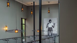 A modern interior with a staircase, glass railings, and pendant lighting.