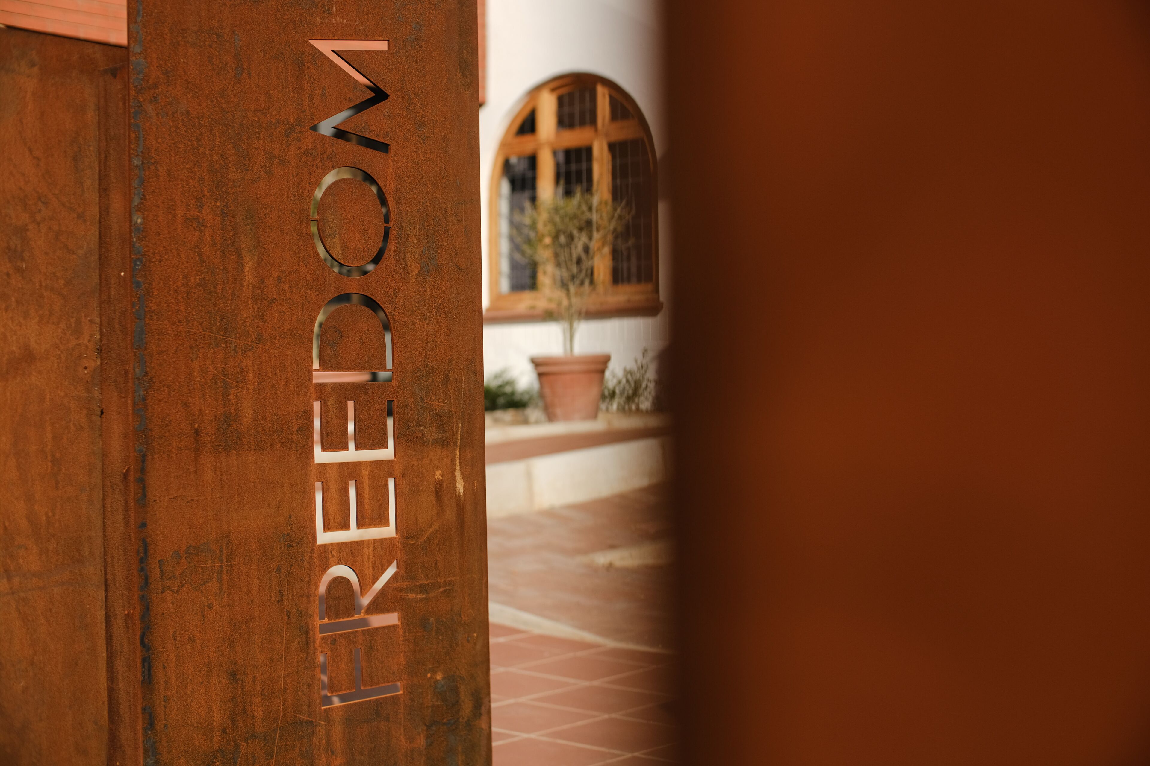 A rustic wooden door with the word "FREEDOM" engraved on it.